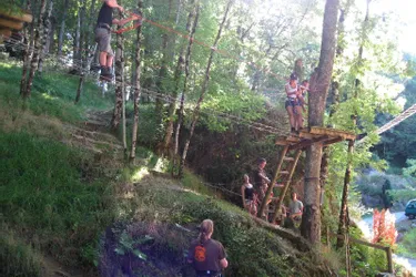Juste en face du château, Val Aventure propose des parcours de grimpe d'arbres, à Lanobre