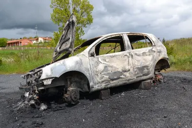 Une voiture posée sur des parpaings et incendiée